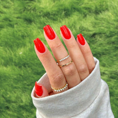 Dazzling Red Dip Powder Nails showcasing a vibrant red manicure with glitter.