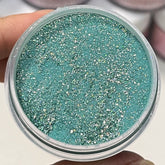 Enchanted Emerald dip powder in deep green with rainbow sparkles