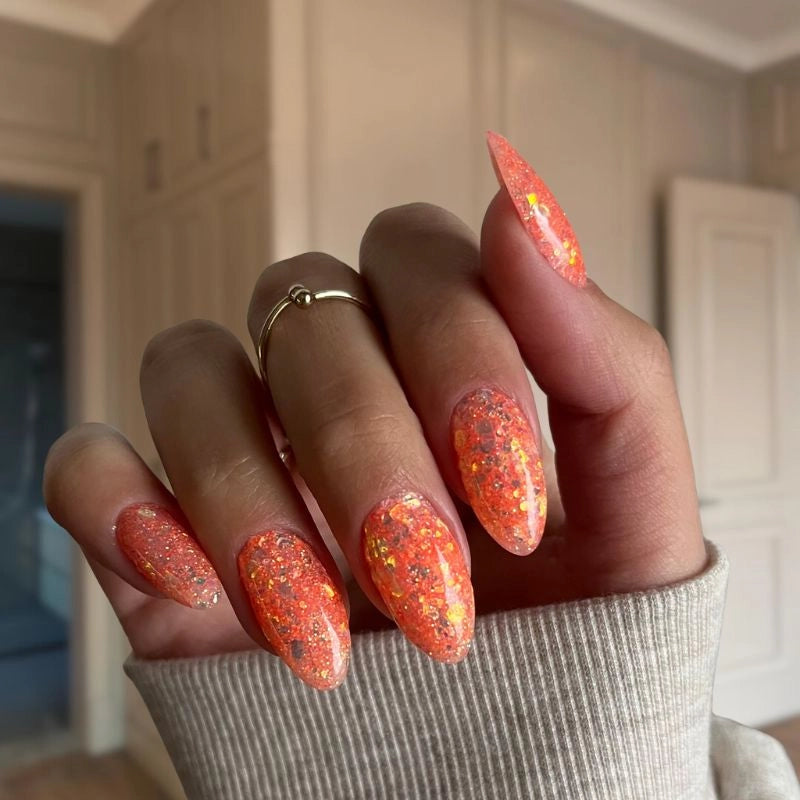 DIY manicure with Mango Orange with Flakes Dip Powder For Nails giving a sparkling, salon-quality look at home.