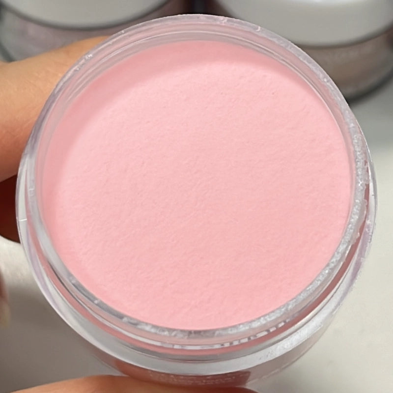 Soft rosy pink dip powder in an open container