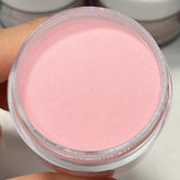Soft rosy pink dip powder in an open container