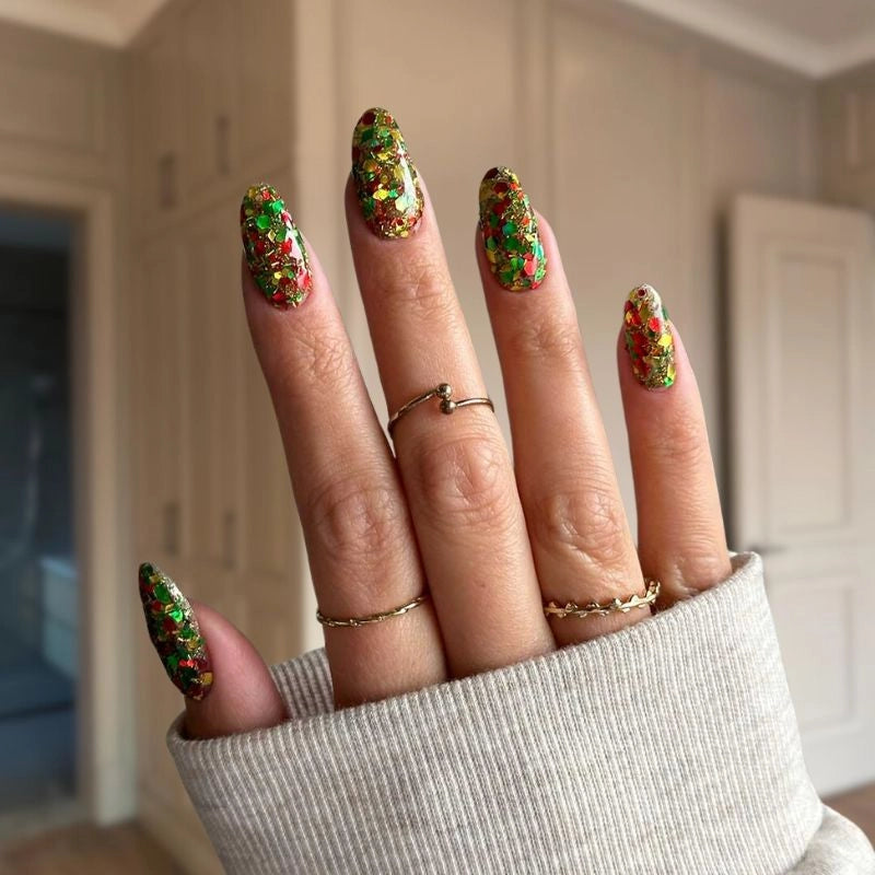 Holiday-inspired Golden Christmas Glitter dip powder for creating dazzling nail art with bright red, green, and yellow glitters.