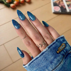 Denim Blue nails with sparkle creating a rich, shimmering blue look that adds a touch of elegance.