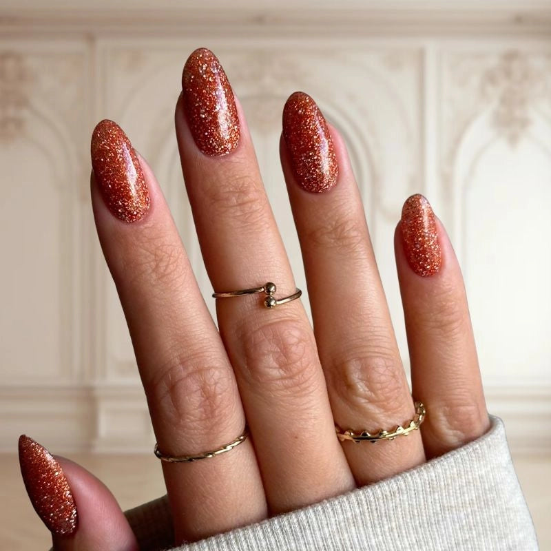 Red Brown nails with glitter, creating a sophisticated and glamorous look with a sparkling finish.